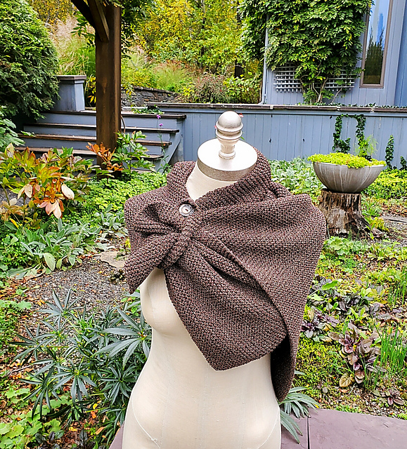 A brown garter shawl fastened around the "shoulders" of a dress form