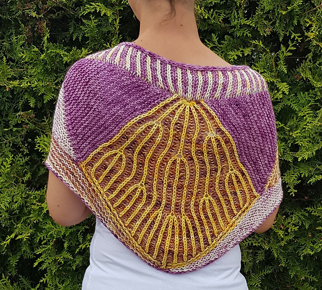 A woman modelling a purple, white, and yellow brioche and garter shawl with decorative brioche increases.