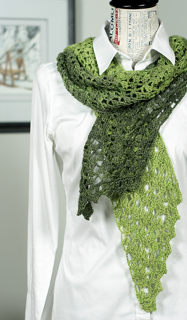 A green crocheted scarf worked on the bias, modelled on a dress form