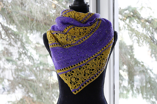 A yellow lace and purple garter striped triangle shawl, displayed on a dress form.