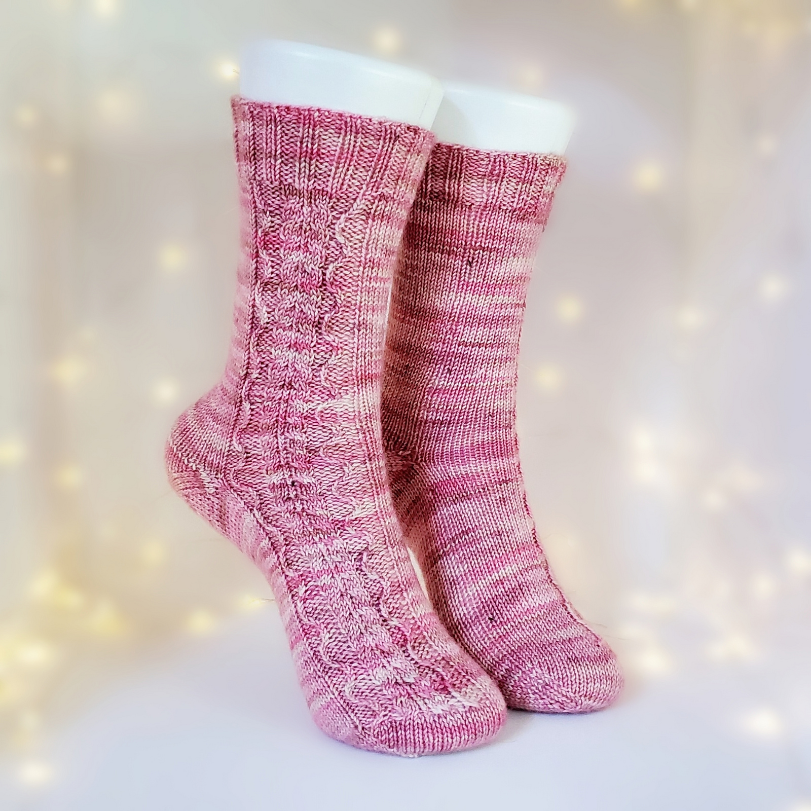 Pink tonal socks with cables running up the side of the instep.