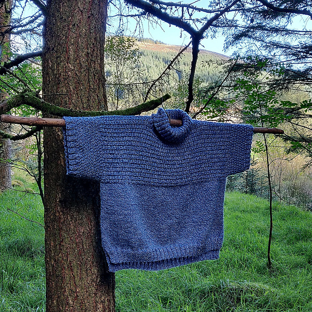 A blue, heavily textured, boxy t-shirt sweater with chunky turtleneck