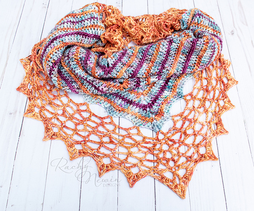 crochet shawl with striped body and an open, wide lace edging with points all around.