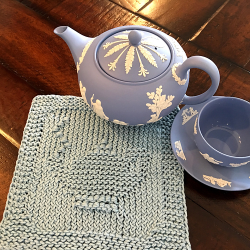 Square washcloth with garter stitch frame and picture of a teapot in the center