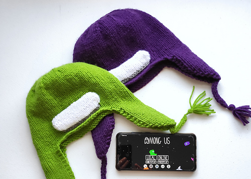 Themed earflap hat from the Among Us game. Hat has a white oval panel attached to the front after knitting, and tassels added to the earflaps.