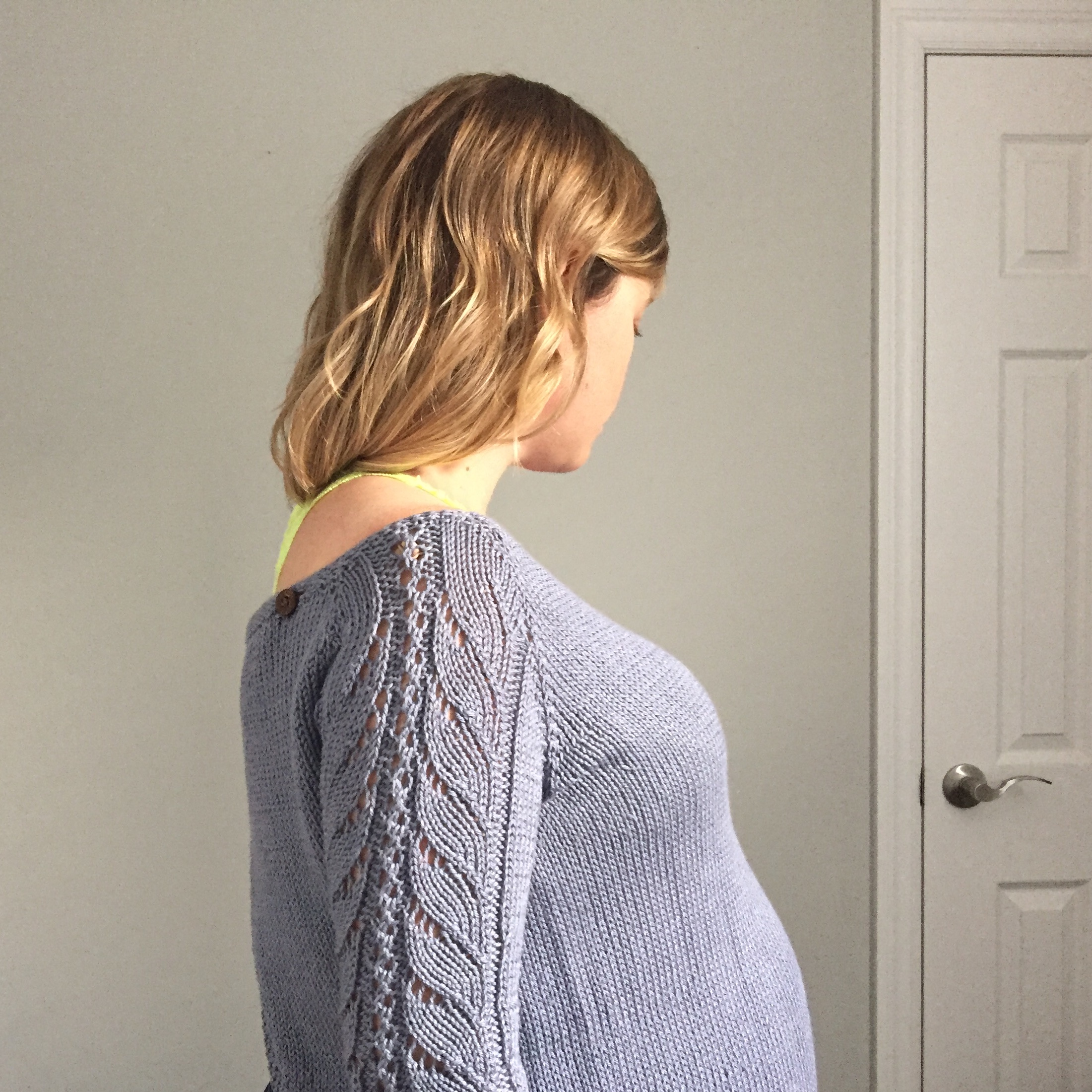 A grey raglan with lace sleeves and unique open-back construction that buttons at the shoulders.